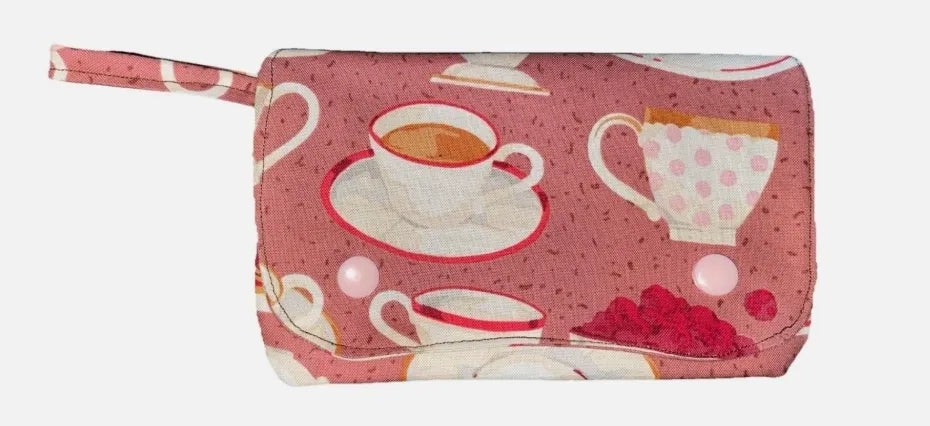 Pink pouch with tea-themed design on a white background