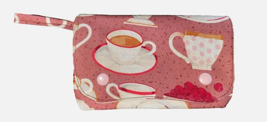 Pink pouch with tea-themed design on a white background