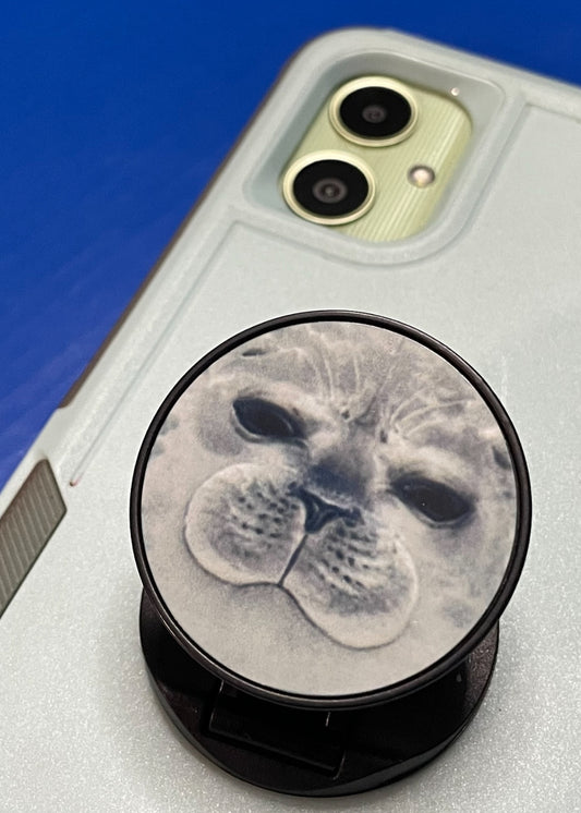 Phone case with a popsocket featuring a seal face design on a blue background