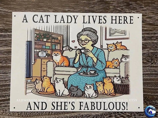 Sign of Cartoon of a woman surrounded by cats with text 'A cat lady lives here and she's fabulous!' on a wooden surface.