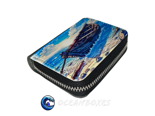 Zipper pouch with a painting of a boat on a beach, branded 'oceanboxes'.