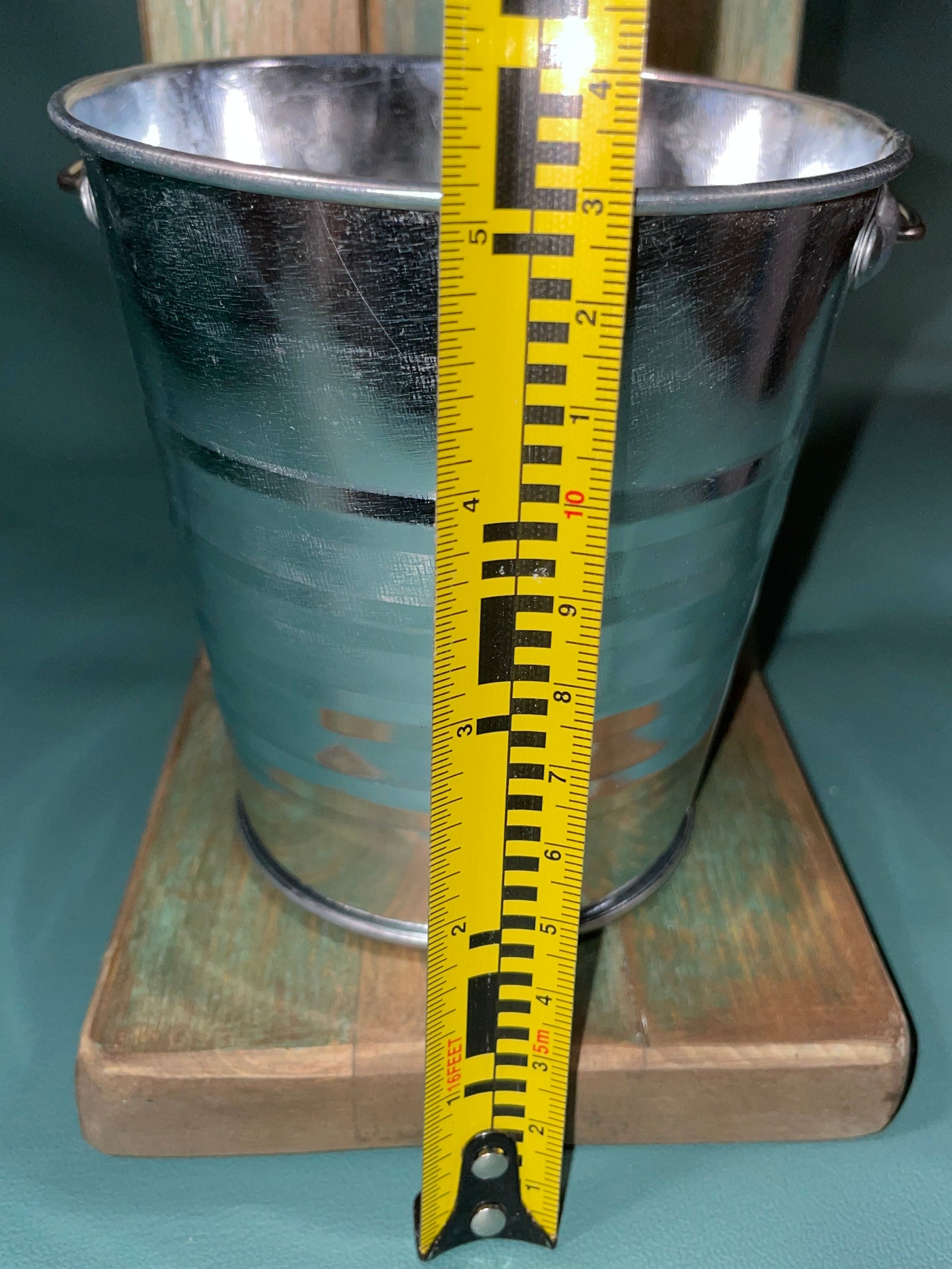 measuring tape against table top wooden plant stand bucket