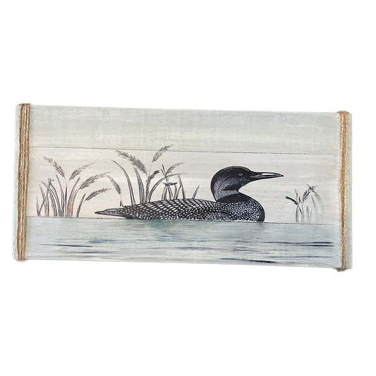 Wooden wall art with a loon and reeds design on a white background