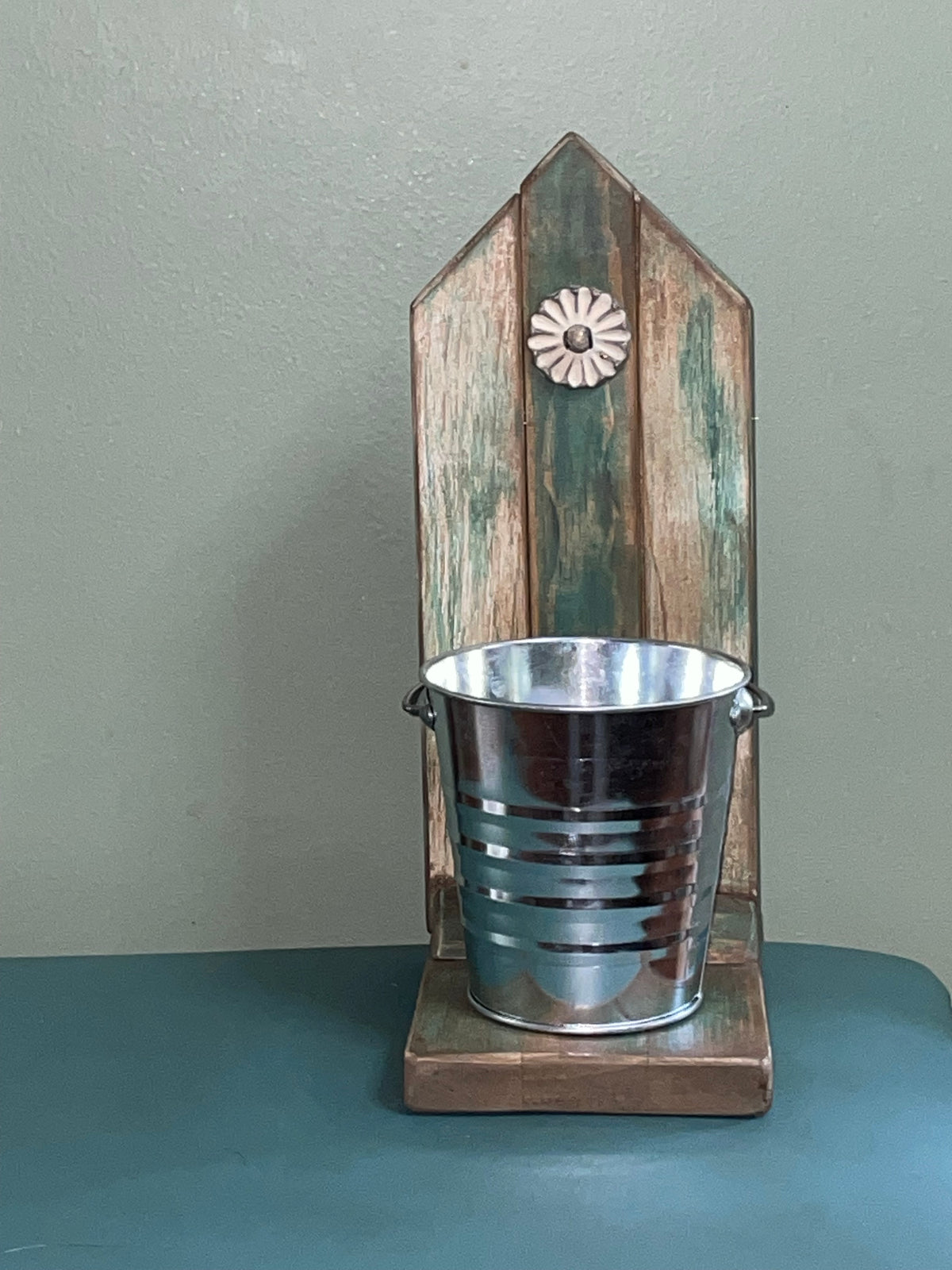 Decorative table top plant stand with bucket and metal flower accent